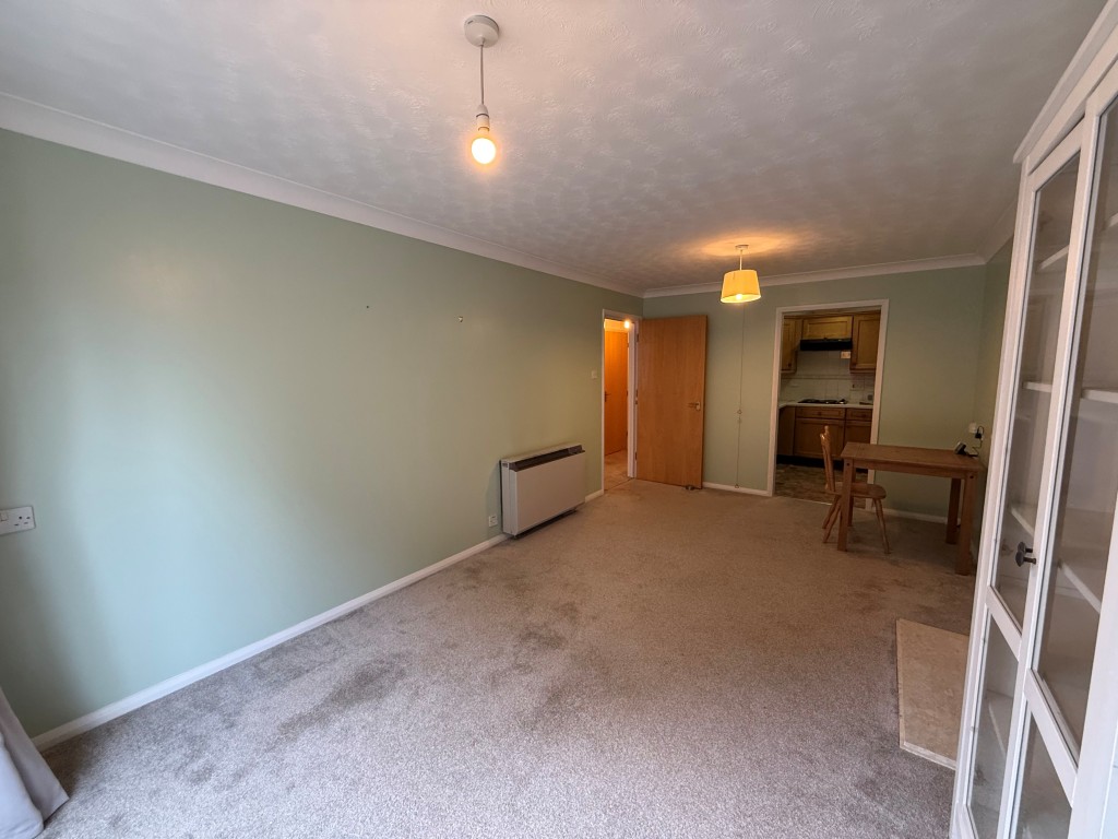 Lot: 73 - ONE-BEDROOM RETIREMENT FLAT - Alternative view of lounge with doorway to kitchen